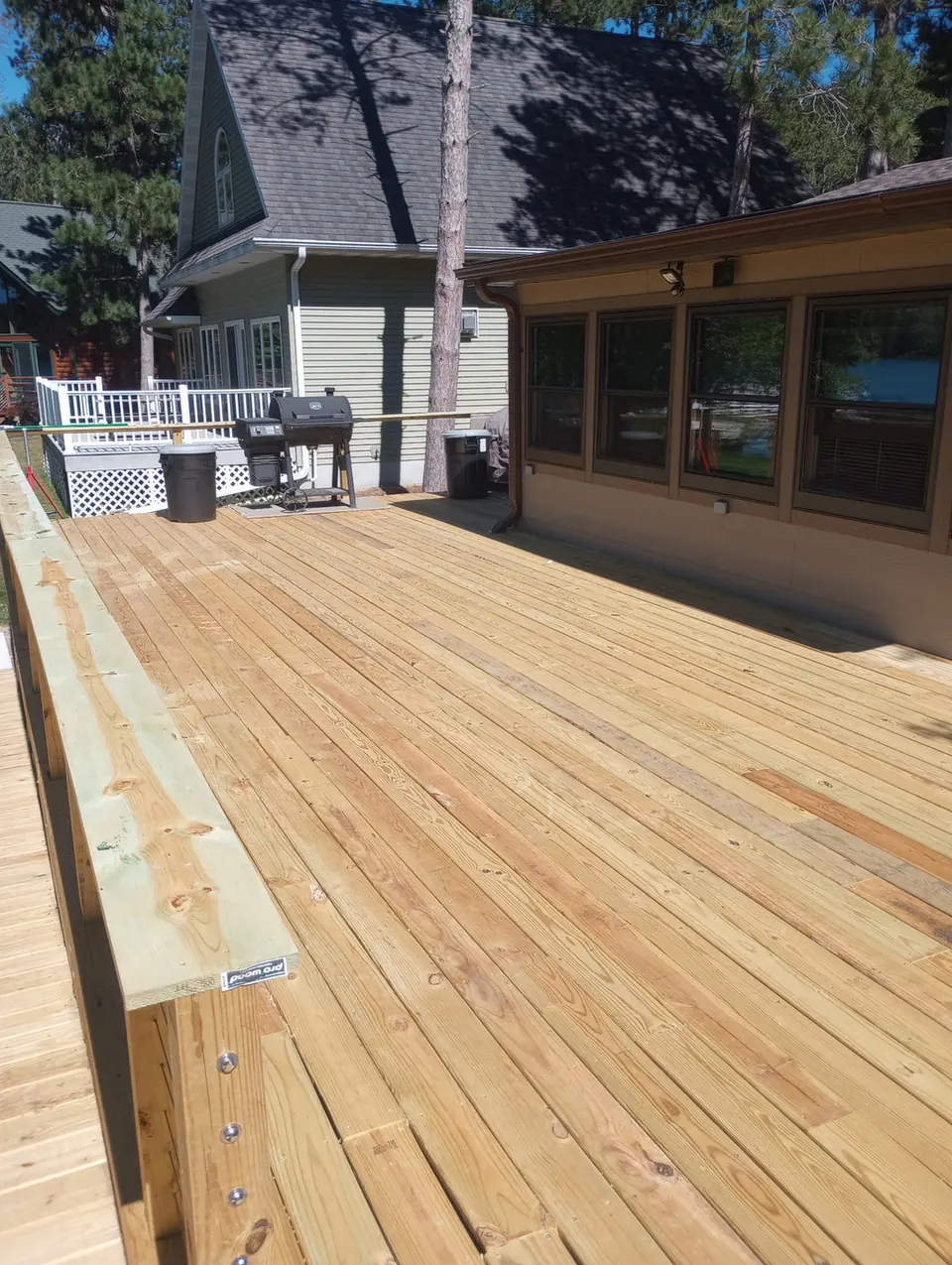 Wide new deck floor beside a screened porch