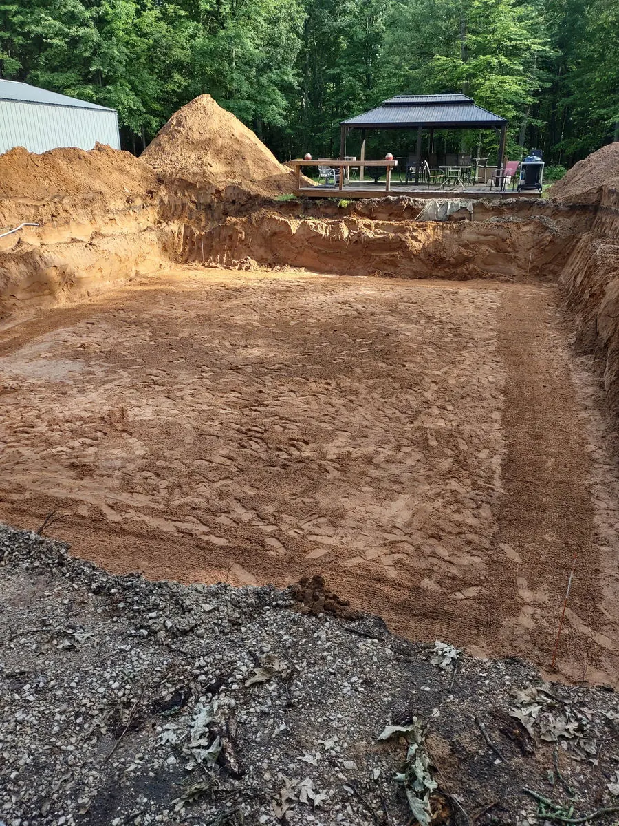 Freshly excavated basement hole with a pile of sand behind it
