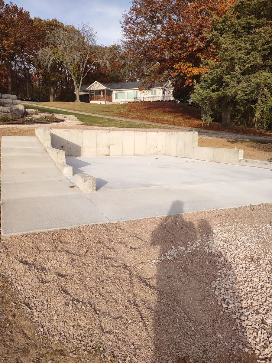 Poured concrete walls stepping down beside a new slab