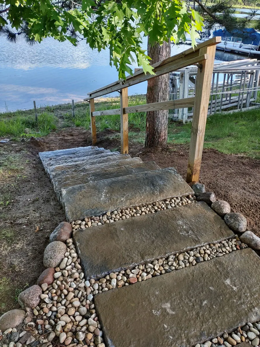 Stone slab path set in river rock leading down to the water