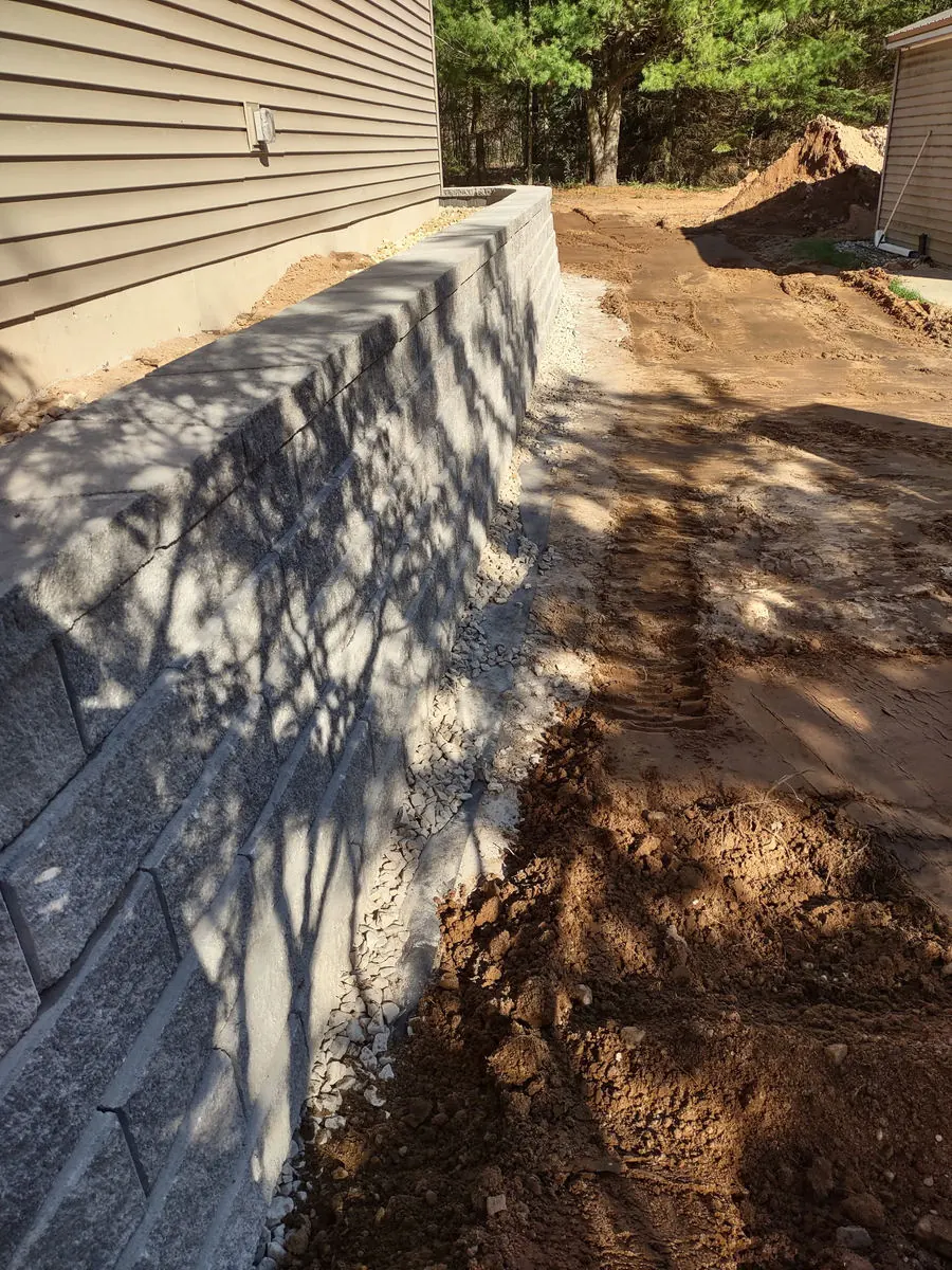 Block retaining wall running along the side of a house
